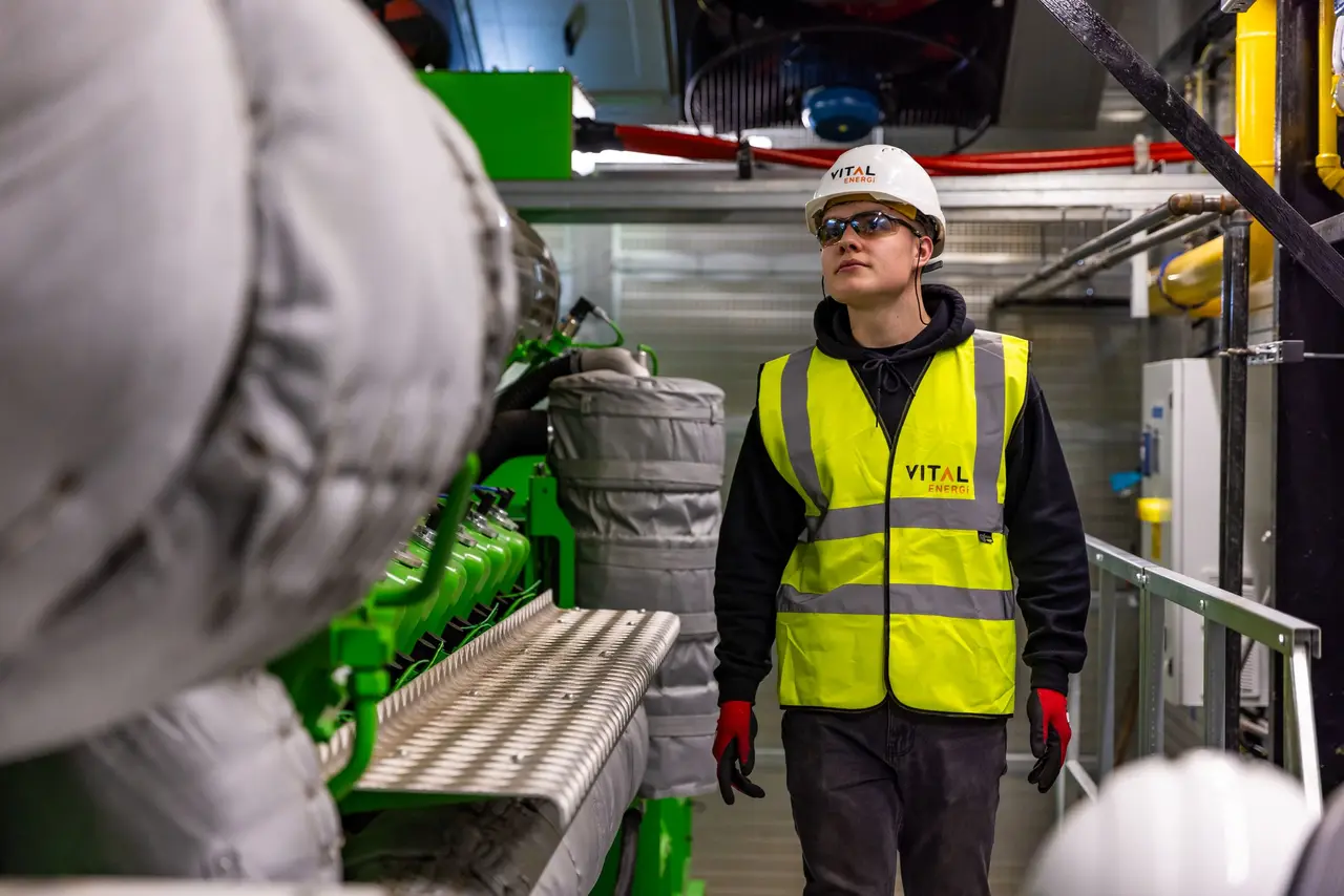 Quality specialist inspecting equipment inside a modern factory